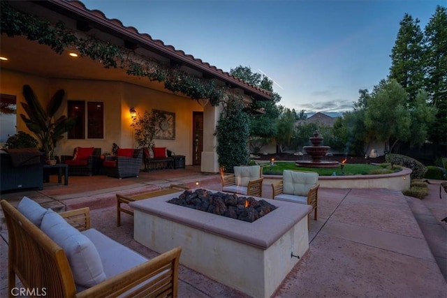 view of patio with an outdoor living space with a fire pit