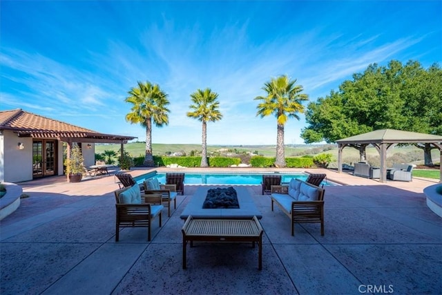 pool with a gazebo, a patio, an outdoor living space with a fire pit, and a jacuzzi