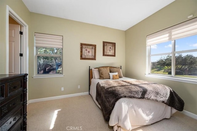 carpeted bedroom with multiple windows and baseboards