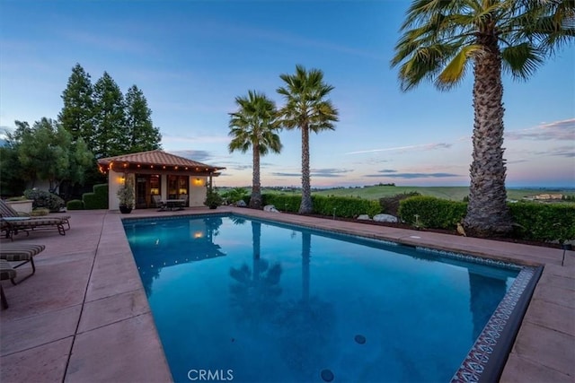 pool featuring a storage structure, a patio, and an outdoor structure