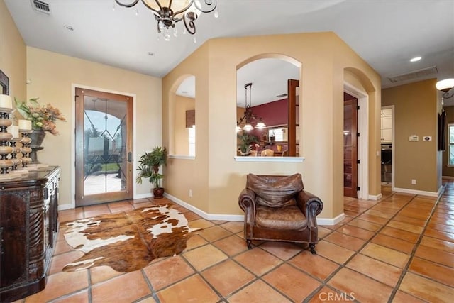 foyer entrance with an inviting chandelier, light tile patterned floors, and visible vents