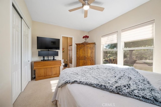 bedroom with light carpet, a closet, and a ceiling fan