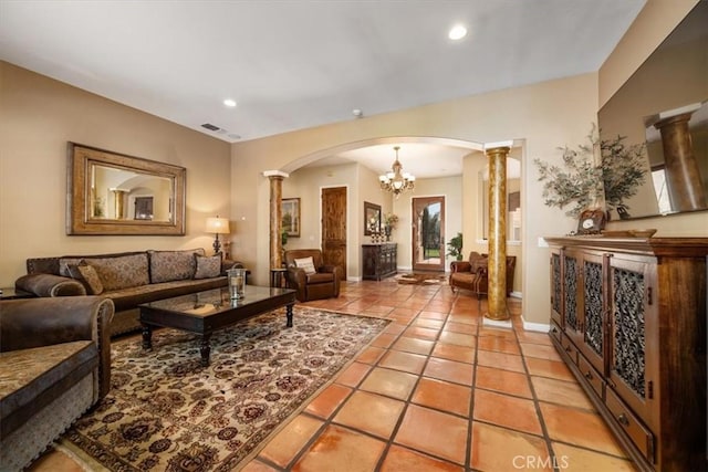 living area featuring decorative columns, visible vents, arched walkways, and light tile patterned flooring