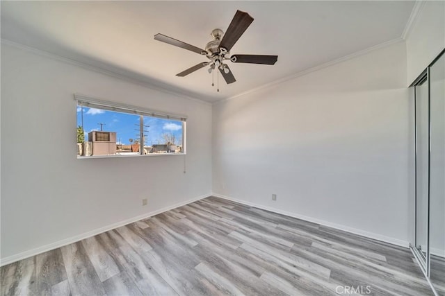 unfurnished room featuring baseboards, ornamental molding, ceiling fan, and wood finished floors