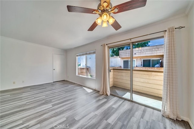 empty room with wood finished floors and crown molding