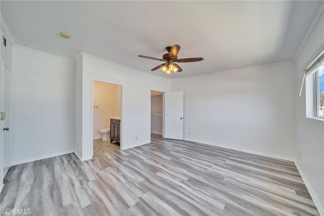 unfurnished bedroom with baseboards, light wood-style floors, a closet, ensuite bath, and crown molding