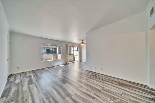 unfurnished living room featuring crown molding, baseboards, and wood finished floors