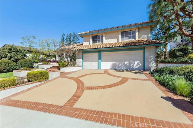 mediterranean / spanish-style house featuring a garage, driveway, a tile roof, and stucco siding