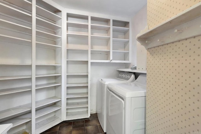 clothes washing area with laundry area, independent washer and dryer, and dark tile patterned floors