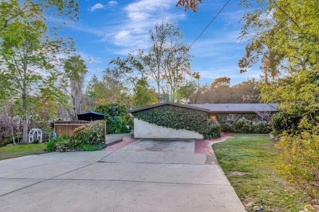 exterior space featuring a wooden deck, a yard, and driveway