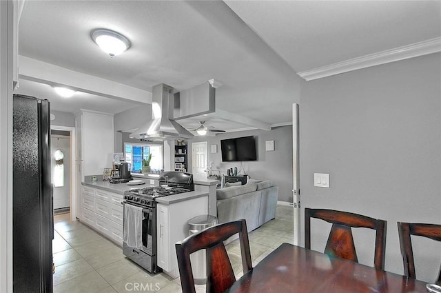 kitchen with gas stove, freestanding refrigerator, white cabinets, a peninsula, and extractor fan