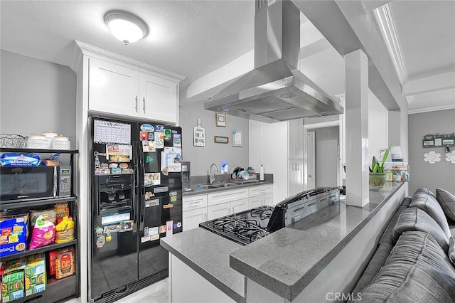 kitchen with island exhaust hood, open floor plan, white cabinets, a sink, and black appliances