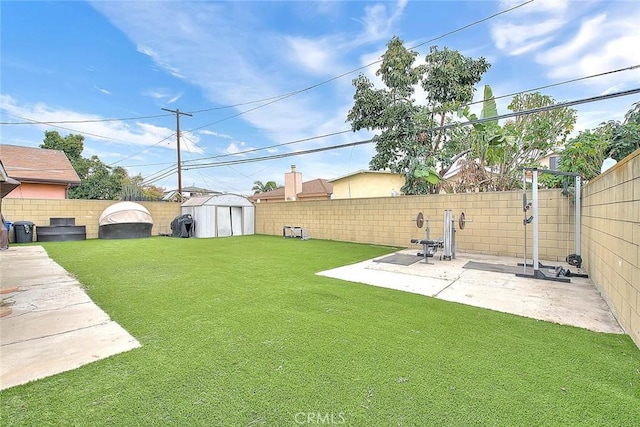 view of yard with a fenced backyard, an outdoor structure, a storage shed, and a patio