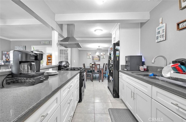 kitchen with light tile patterned floors, white cabinets, wall chimney exhaust hood, black appliances, and a sink