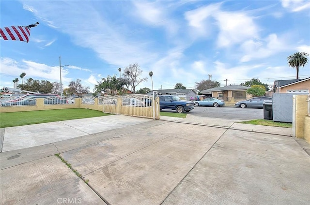 view of road featuring driveway and a gate