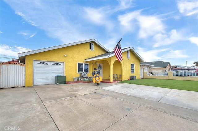 view of front facade featuring a gate, a front yard, fence, and stucco siding