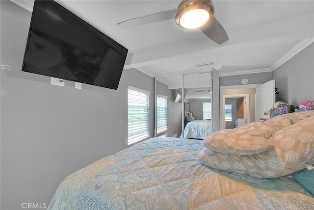 bedroom featuring ornamental molding, a closet, visible vents, and ceiling fan