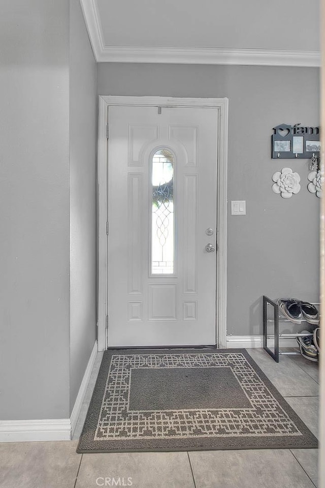 tiled foyer featuring baseboards and ornamental molding