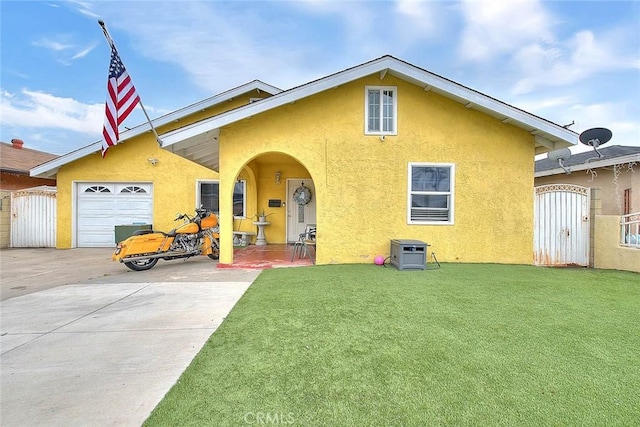 view of front facade with a front yard, a garage, a gate, and stucco siding