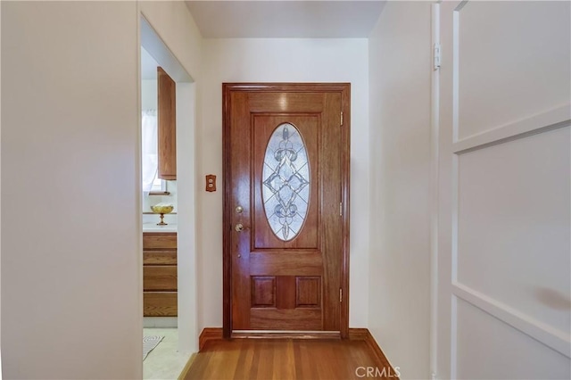 doorway to outside with baseboards and wood finished floors