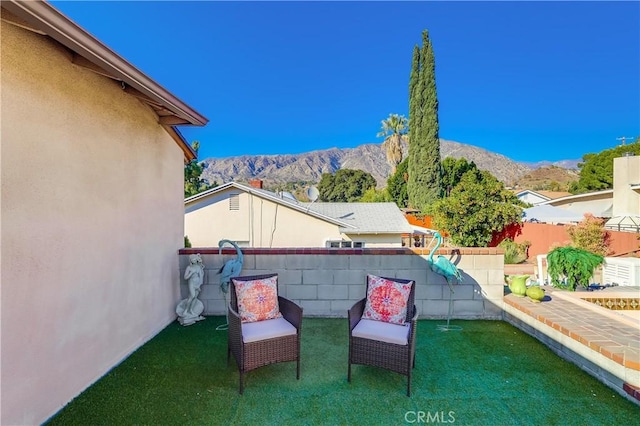 view of patio with fence and a mountain view