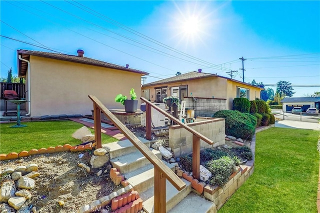 view of property exterior with a lawn, fence, and stucco siding