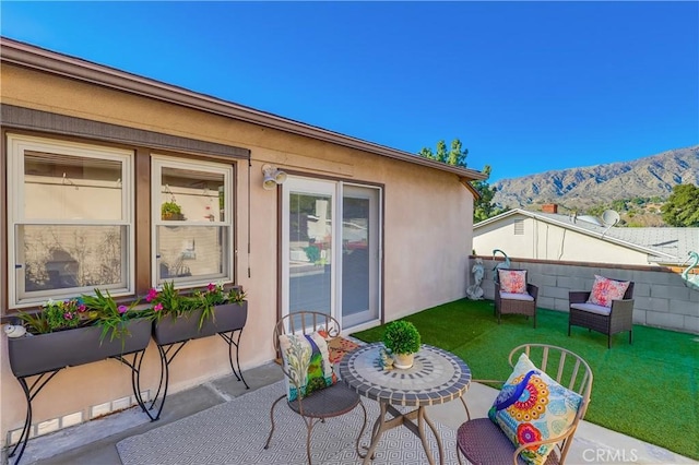 view of patio with fence and a mountain view