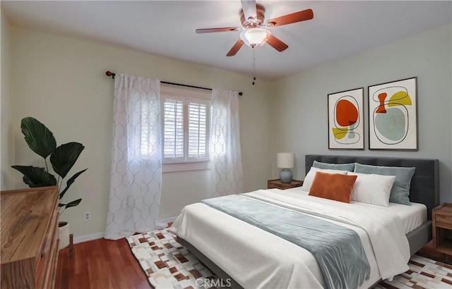 bedroom featuring a ceiling fan, baseboards, and wood finished floors