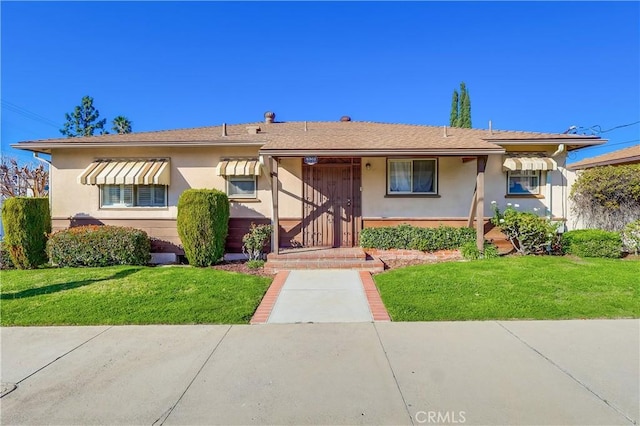 view of front of home with a front lawn and stucco siding