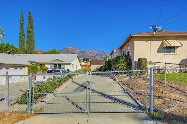 view of gate with fence and a mountain view