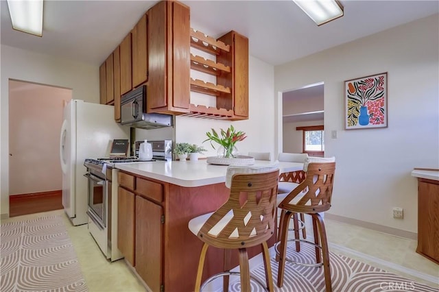 kitchen with open shelves, light countertops, brown cabinetry, black microwave, and stainless steel gas range oven