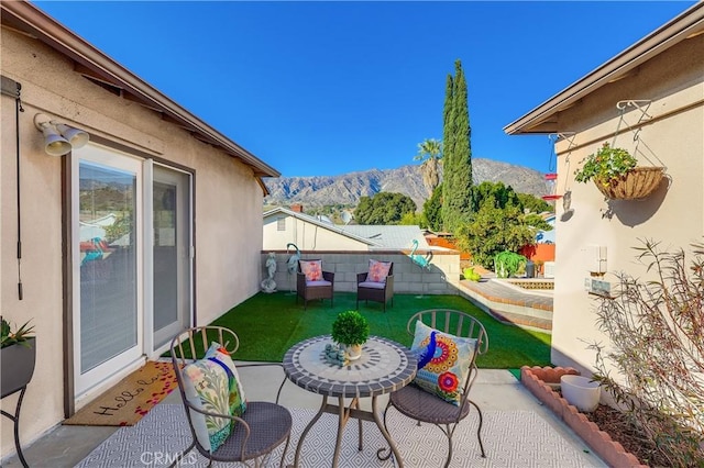 view of patio featuring fence and a mountain view