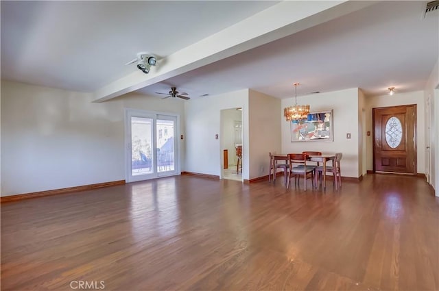 interior space featuring ceiling fan with notable chandelier, dark wood-type flooring, visible vents, baseboards, and beam ceiling