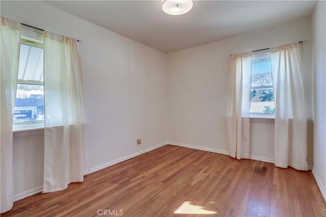 unfurnished room featuring baseboards and light wood finished floors