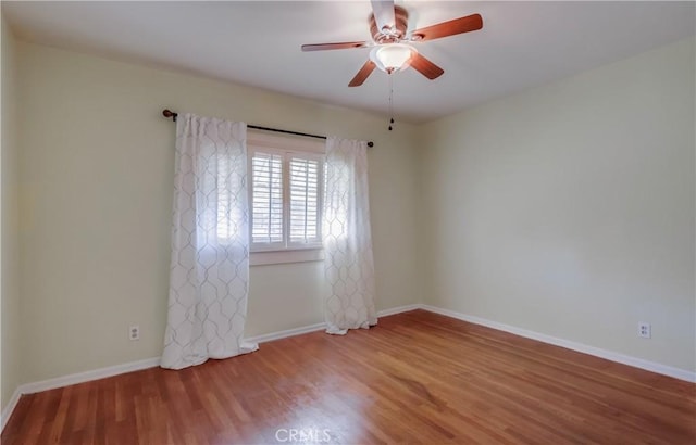 spare room with ceiling fan, baseboards, and wood finished floors