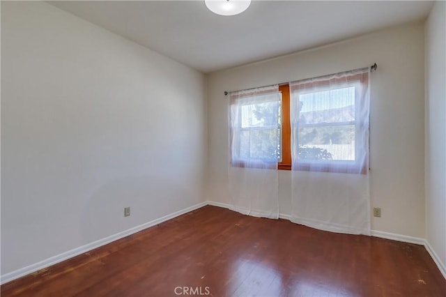 spare room with wood finished floors and baseboards