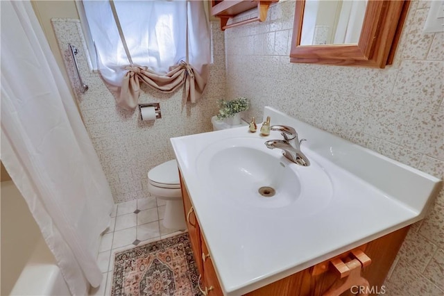 bathroom with tile patterned flooring, tile walls, vanity, and toilet