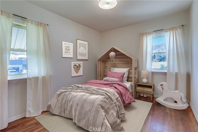 bedroom featuring baseboards and wood finished floors