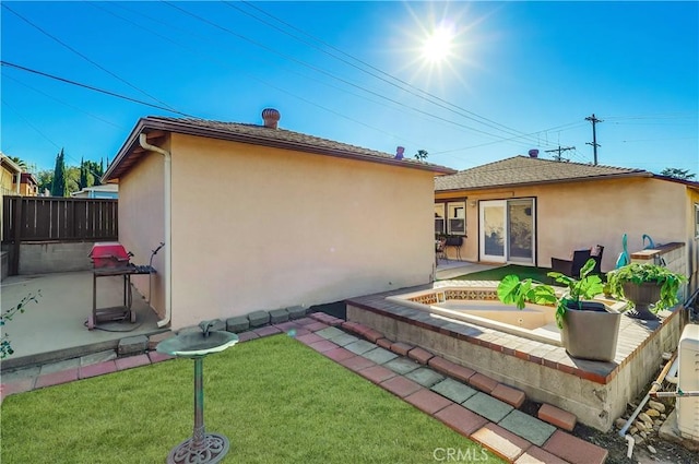 back of property with a lawn, a patio area, fence, and stucco siding