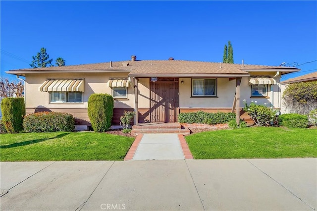 view of front of home featuring a front yard and stucco siding