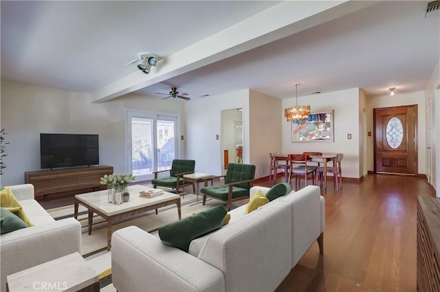 living room featuring ceiling fan with notable chandelier, beam ceiling, visible vents, and wood finished floors