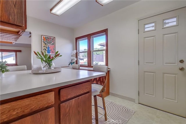 kitchen featuring a breakfast bar area, brown cabinets, and light countertops