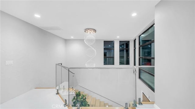 hallway featuring recessed lighting, an upstairs landing, and an inviting chandelier