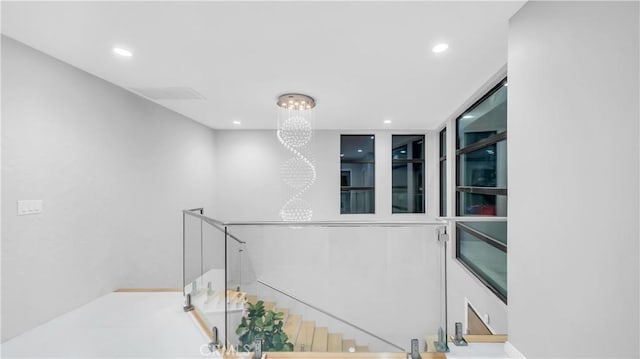 hallway with recessed lighting, an upstairs landing, and a notable chandelier