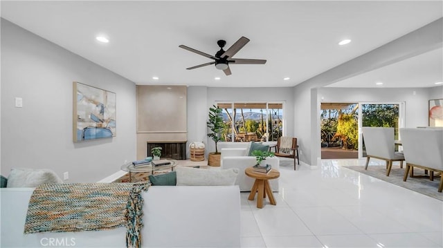 living room featuring a ceiling fan, recessed lighting, baseboards, and a large fireplace