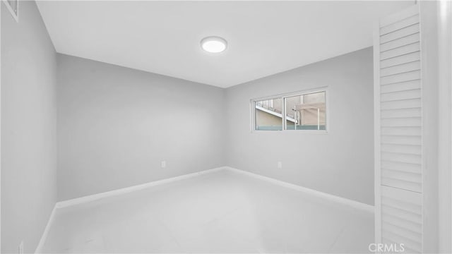 unfurnished room with baseboards