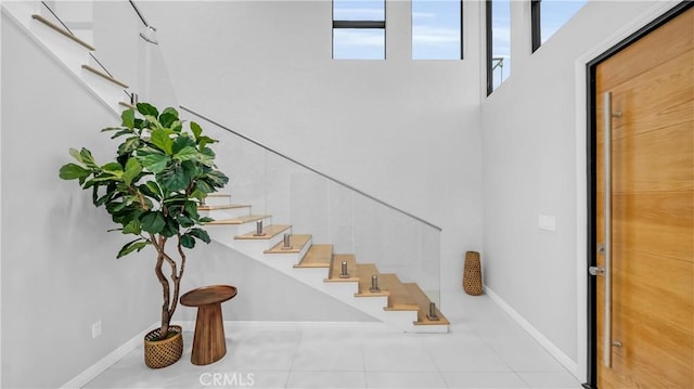 staircase featuring tile patterned flooring and baseboards