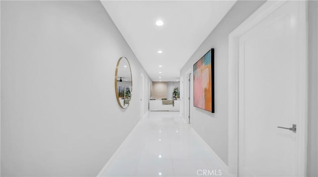 hallway featuring recessed lighting, baseboards, and tile patterned floors