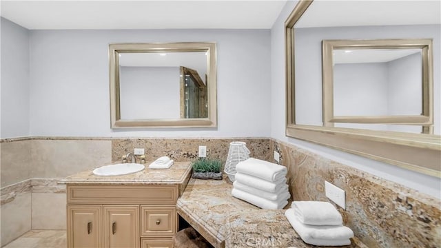 bathroom with a wainscoted wall, vanity, and tile walls