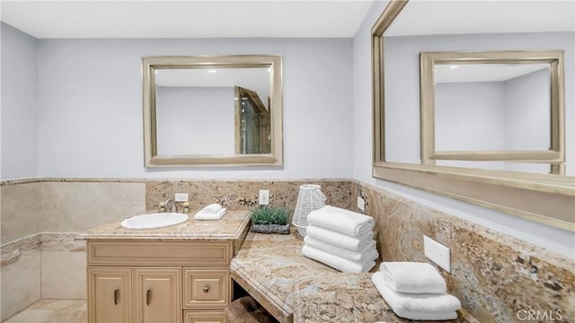 bathroom featuring vanity, tile walls, and a wainscoted wall
